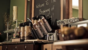 A coffee station with a chalkboard sign saying "Welcome to the Beginning of Day!" and various coffee-making equipment. - AmericInn by Wyndham Fargo West Acres (Fargo)