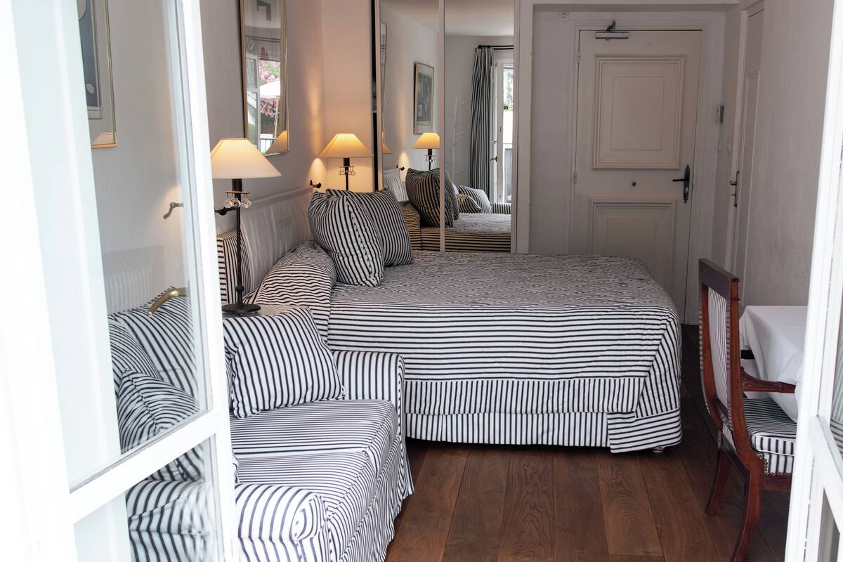 Ein Schlafzimmer mit einem großen Bett, zwei Nachttischen und einem Sessel.