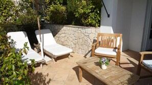 A patio with two white lounge chairs, a wooden chair, and a small table with a potted plant. - Les Vergers de Saint-Paul (Saint-Paul-de-Vence)