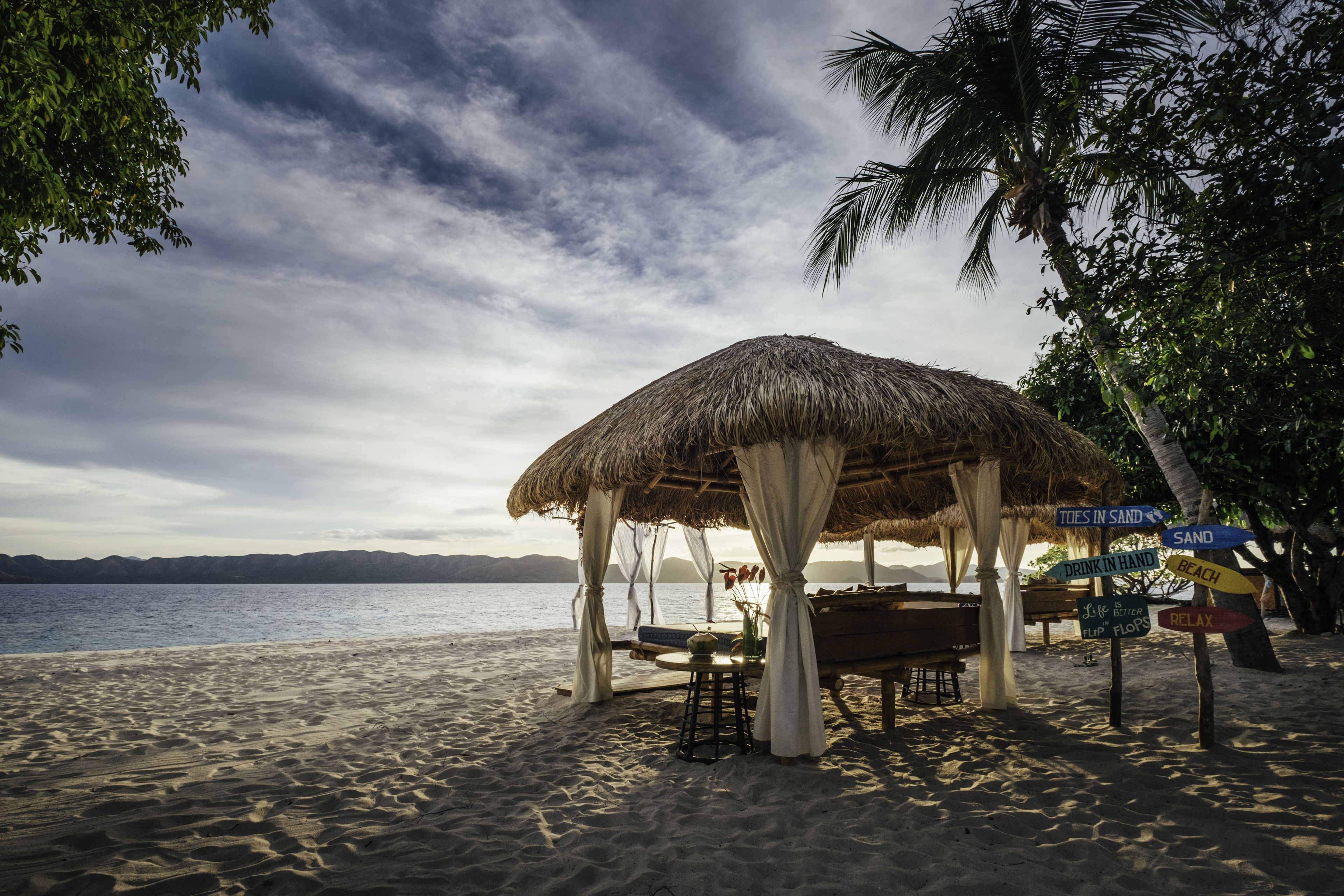 Praia particular, areia branca, espreguiçadeiras, guarda-sóis 