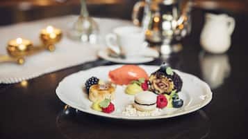 Um prato de sobremesas com vários doces e frutas sobre uma mesa.