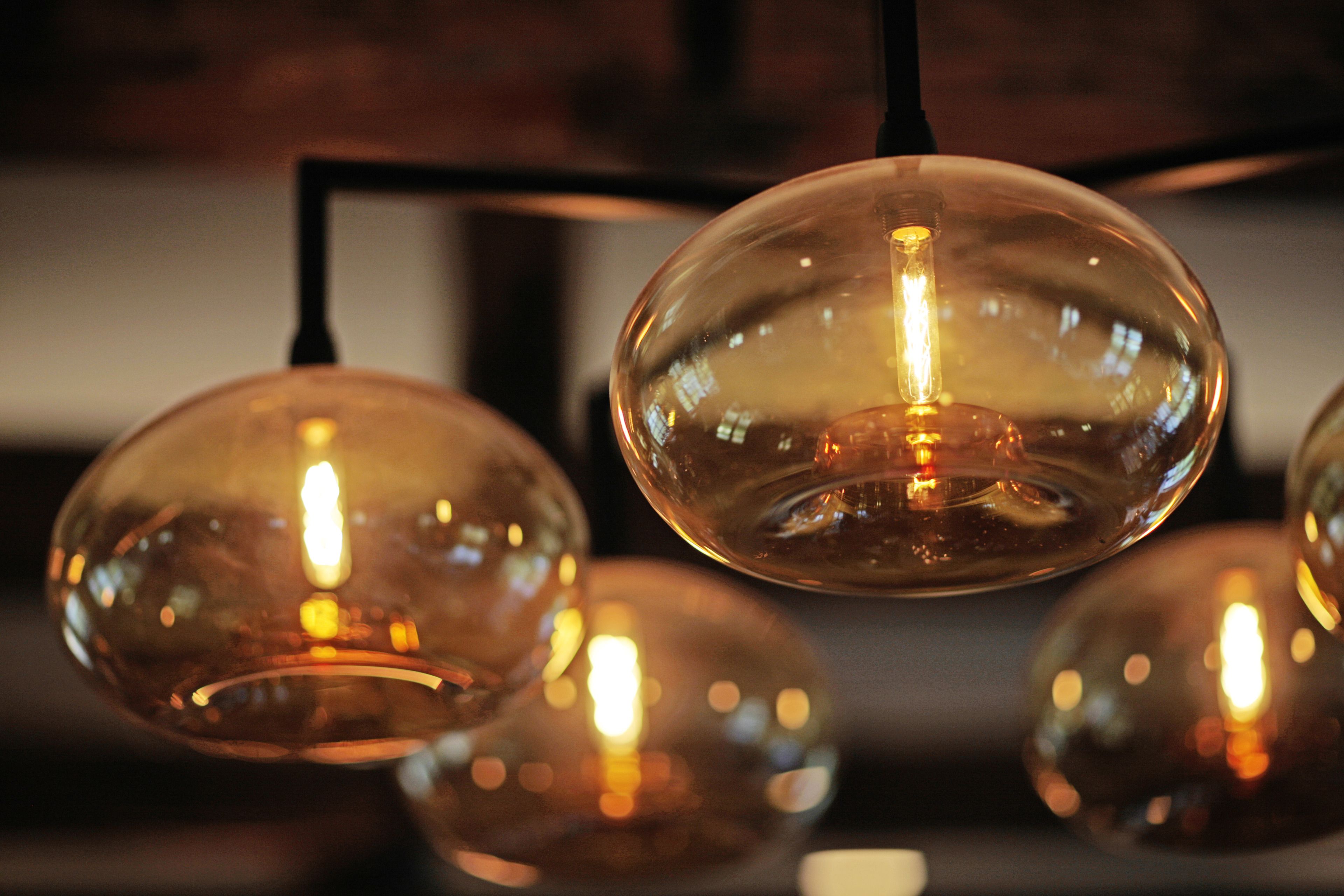 A close-up of several spherical glass pendant lights with visible filament bulbs.