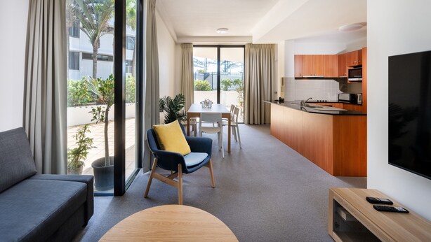 Una habitación de hotel moderna con sala de estar, comedor y kitchenette.