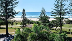 A beach view with pine trees and a clear sky. - Mantra Coolangatta Beach (Coolangatta)