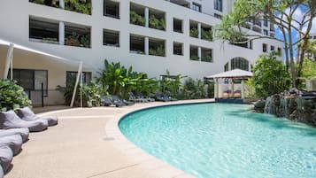 Relax by the pool surrounded by lounge chairs and a covered seating area.