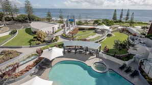 A resort with a swimming pool, outdoor seating, and a view of the ocean. - Mantra Mooloolaba Beach (Mooloolaba)