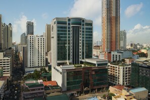 Un grand hôtel, avec un imposant panneau « Sheraton » bien visible, entouré d’autres immeubles de grande hauteur dans un environnement urbain.