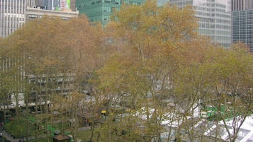Un paysage urbain avec des immeubles modernes de grande hauteur et un espace vert arboré.