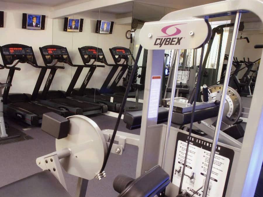 Een fitnessruimte met loopbanden, een Cyrex machine en trainingsapparatuur.