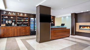 A modern kitchen area with a pantry, a refrigerator, and a flat-screen TV. - Four Points by Sheraton Surrey (Surrey)