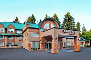 A Four Points by Sheraton hotel with a distinctive curved entrance and a green roof. - Four Points by Sheraton Surrey (Surrey)