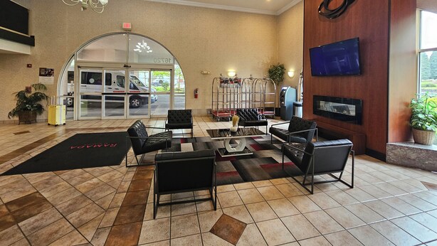 A lobby with a reception desk, seating area, and a TV mounted on the wall.