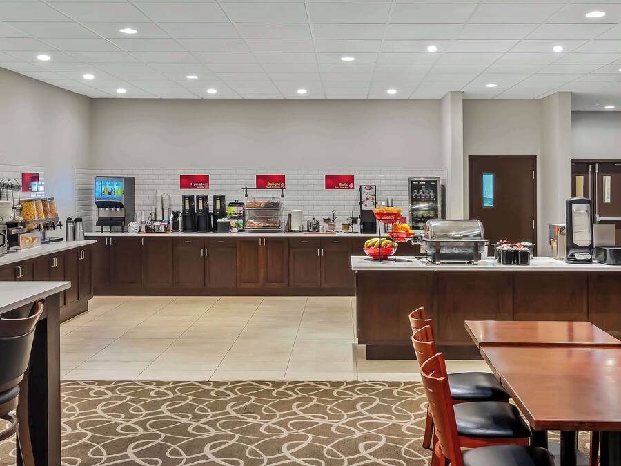 A modern hotel kitchen with a central island, a coffee machine, and a buffet area.