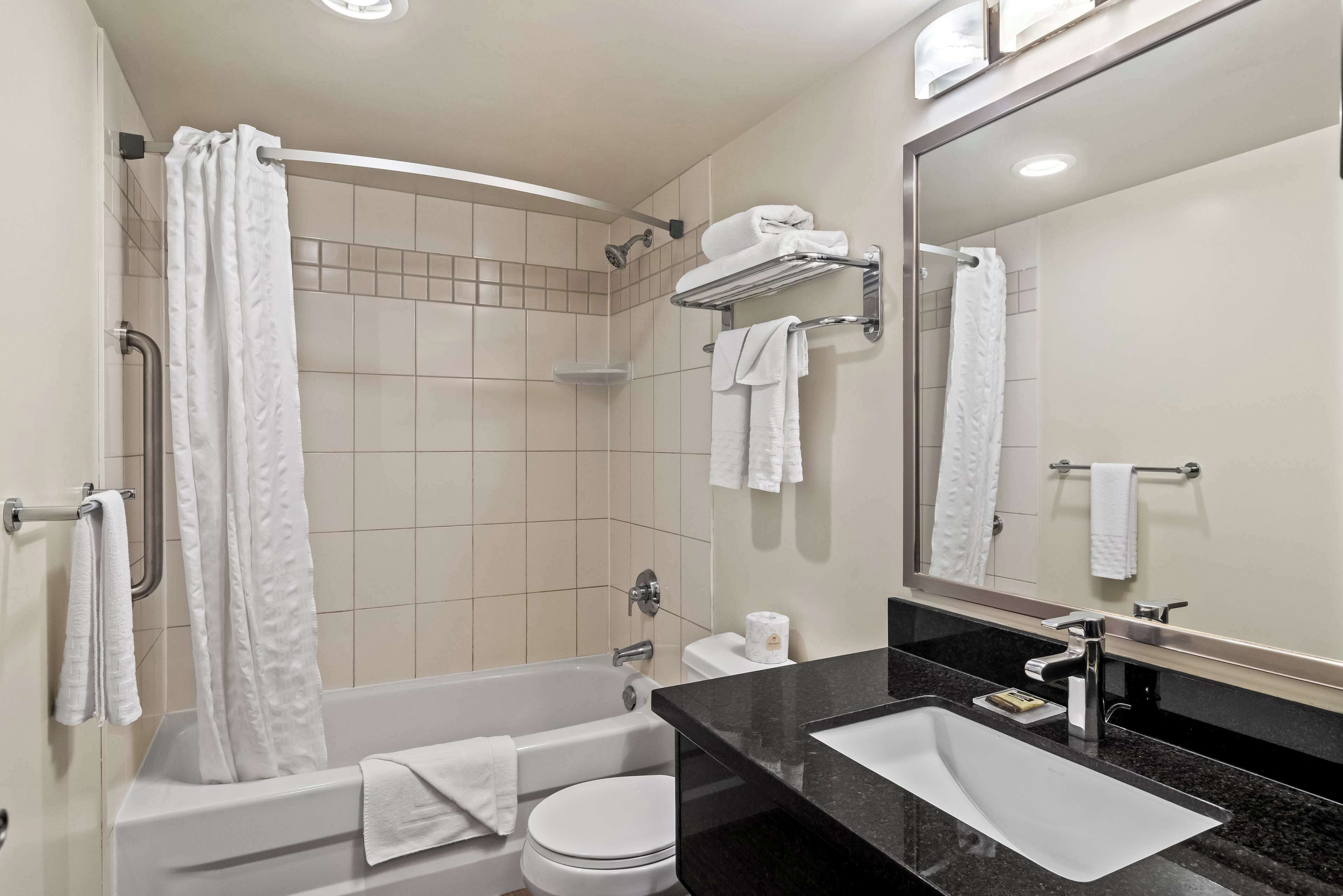 A modern bathroom with a bathtub, toilet, and sink.