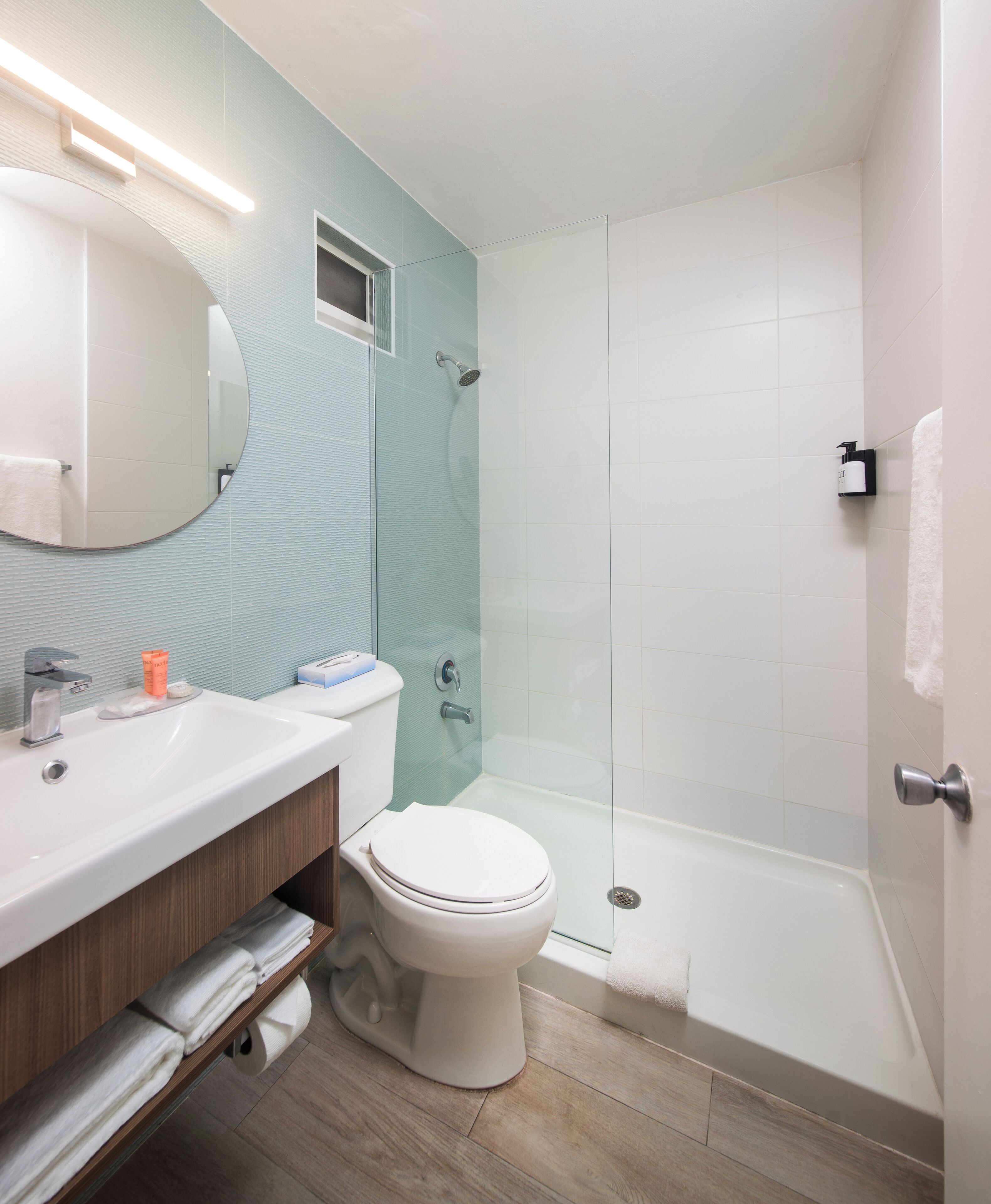 A modern bathroom with a sink, toilet, and shower area.