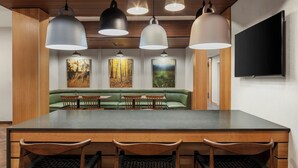 Un comedor moderno con una mesa larga, sillas de madera e iluminación colgante.