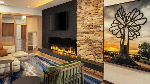 Una sala de estar moderna con chimenea, un televisor de pantalla plana y una pared de acento de piedra.