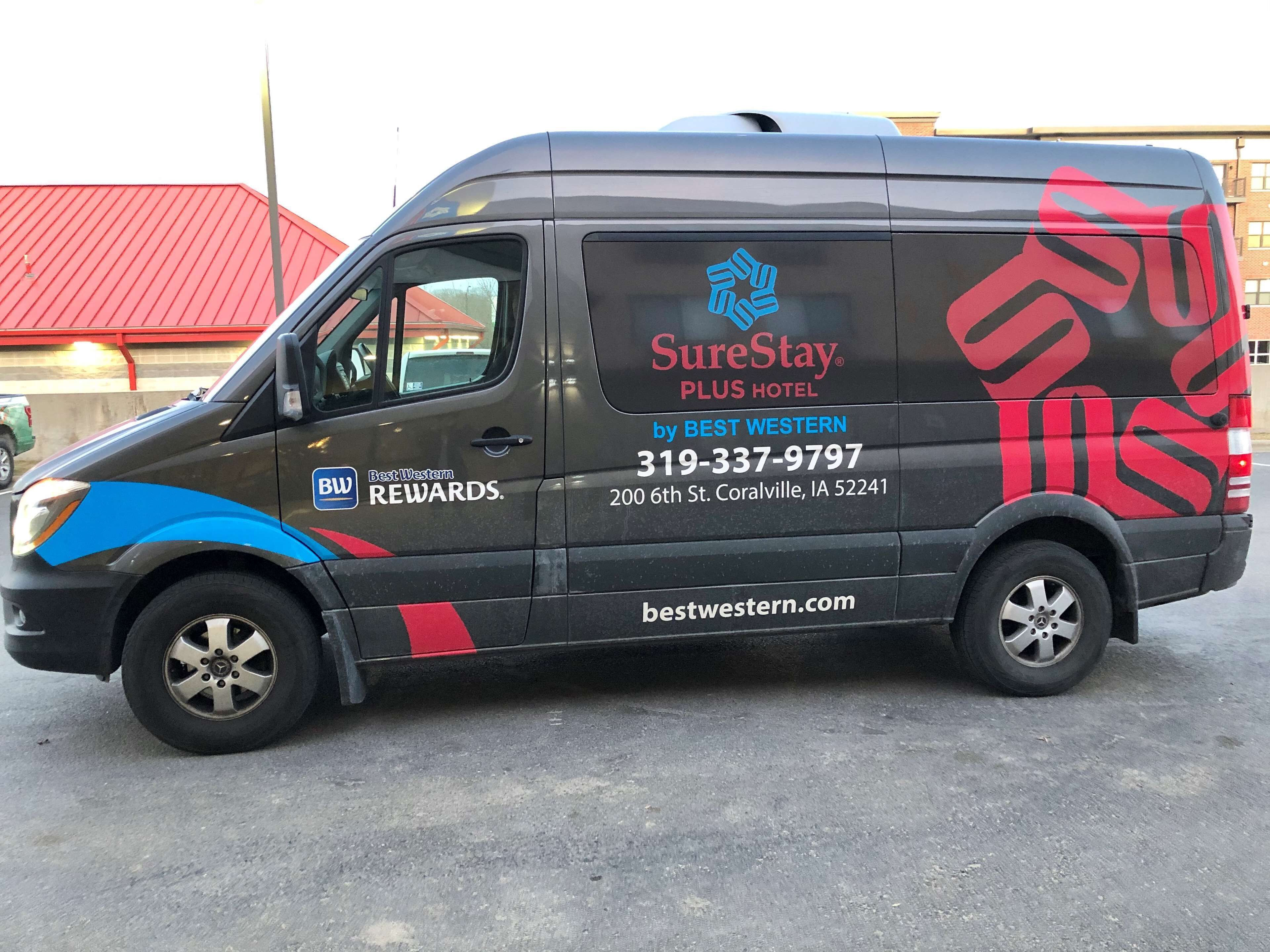 A van with the text "SureStay PLUS HOTEL by BEST WESTERN" and a phone number.