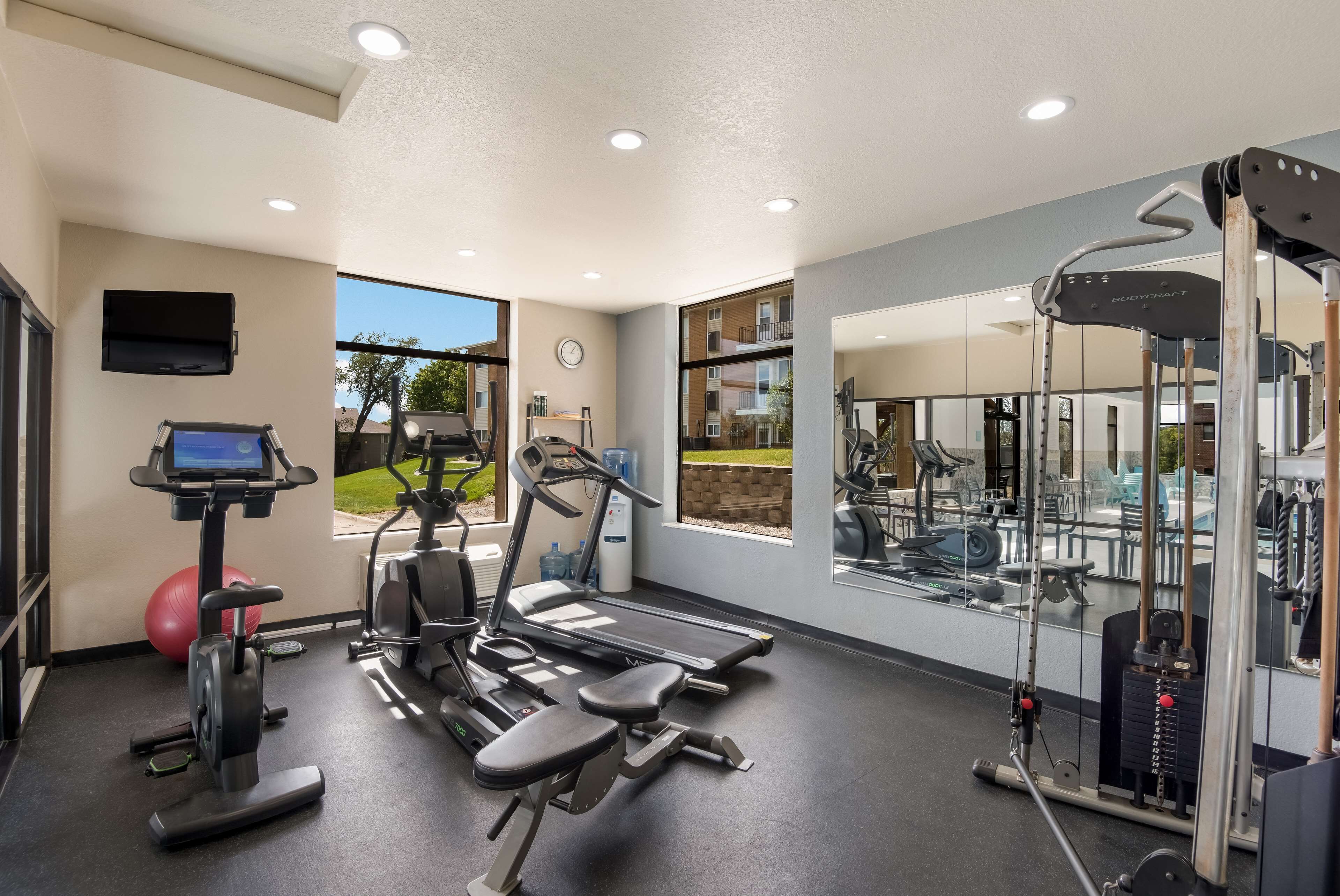 A gym with treadmills, elliptical machines, and a weight machine.
