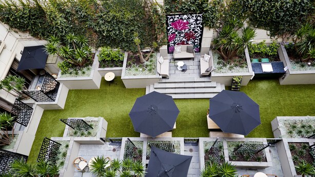 A rooftop garden with seating areas, a decorative wall, and a variety of plants. - The Sebel Melbourne Flinders Lane (Melbourne)