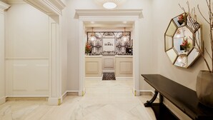 A hallway with a bench, a mirror, and a door leading to a room labeled "The Sebel". - The Sebel Melbourne Flinders Lane (Melbourne)