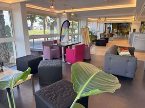 Een modern interieur met zitplaatsen, een eethoek en grote ramen.