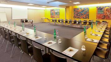 A conference room with long tables, chairs, and water bottles.