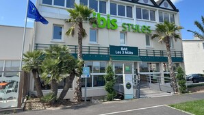 Een gebouw met een bord waarop 'bar Les 3 Mâts' en 'ibis Styles' staat, wat een bar en restaurant aangeeft.