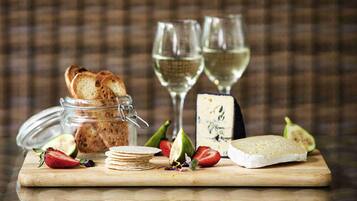 A wooden board with cheese, strawberries, and a jar of bread.
