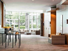 Una habitación amplia y moderna con ventanas grandes, un comedor y asientos cómodos.