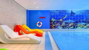 Una piscina techada, sillones reclinables de piscina