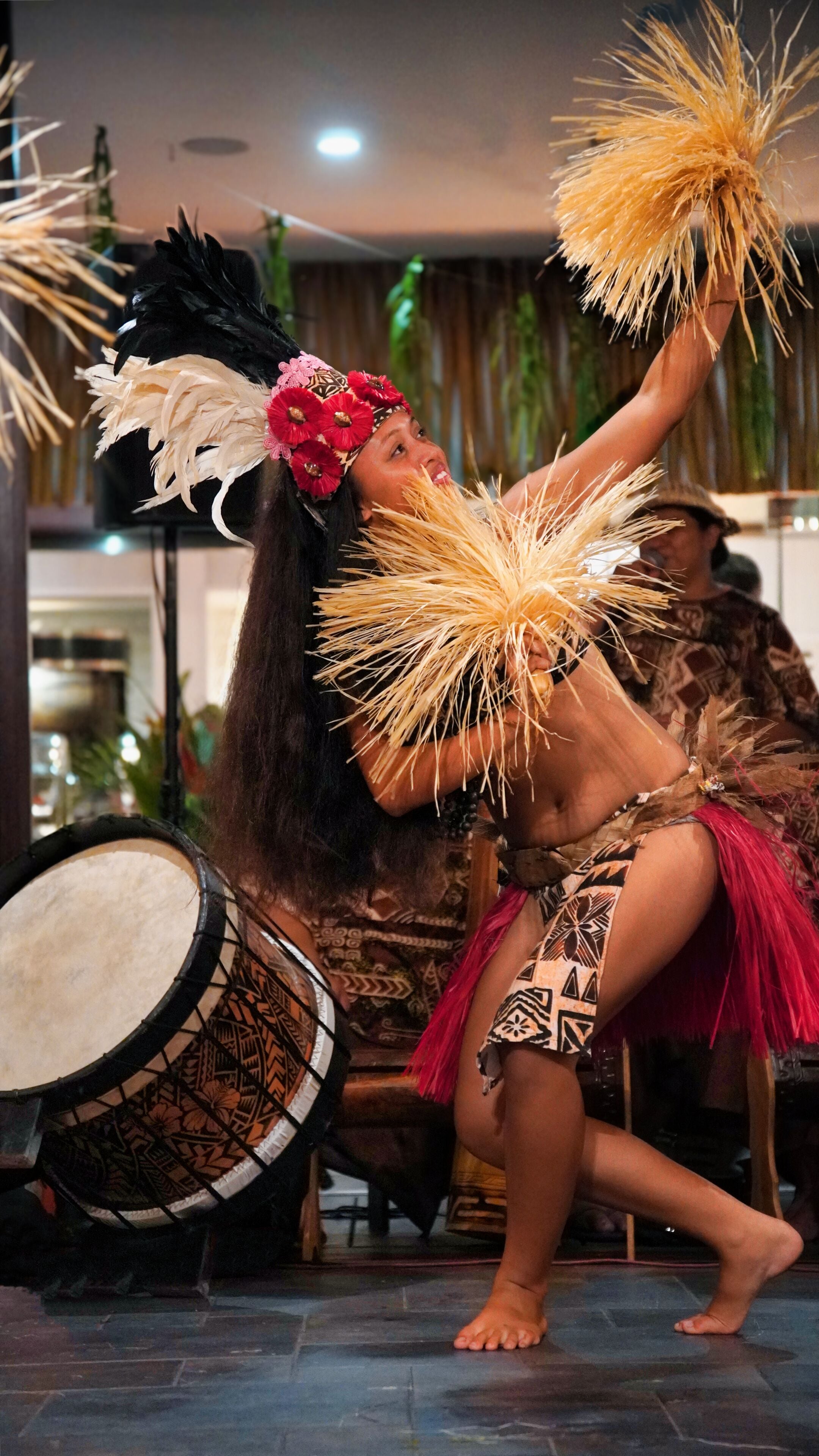 Una persona actuando con un tambor y accesorios de plumas.