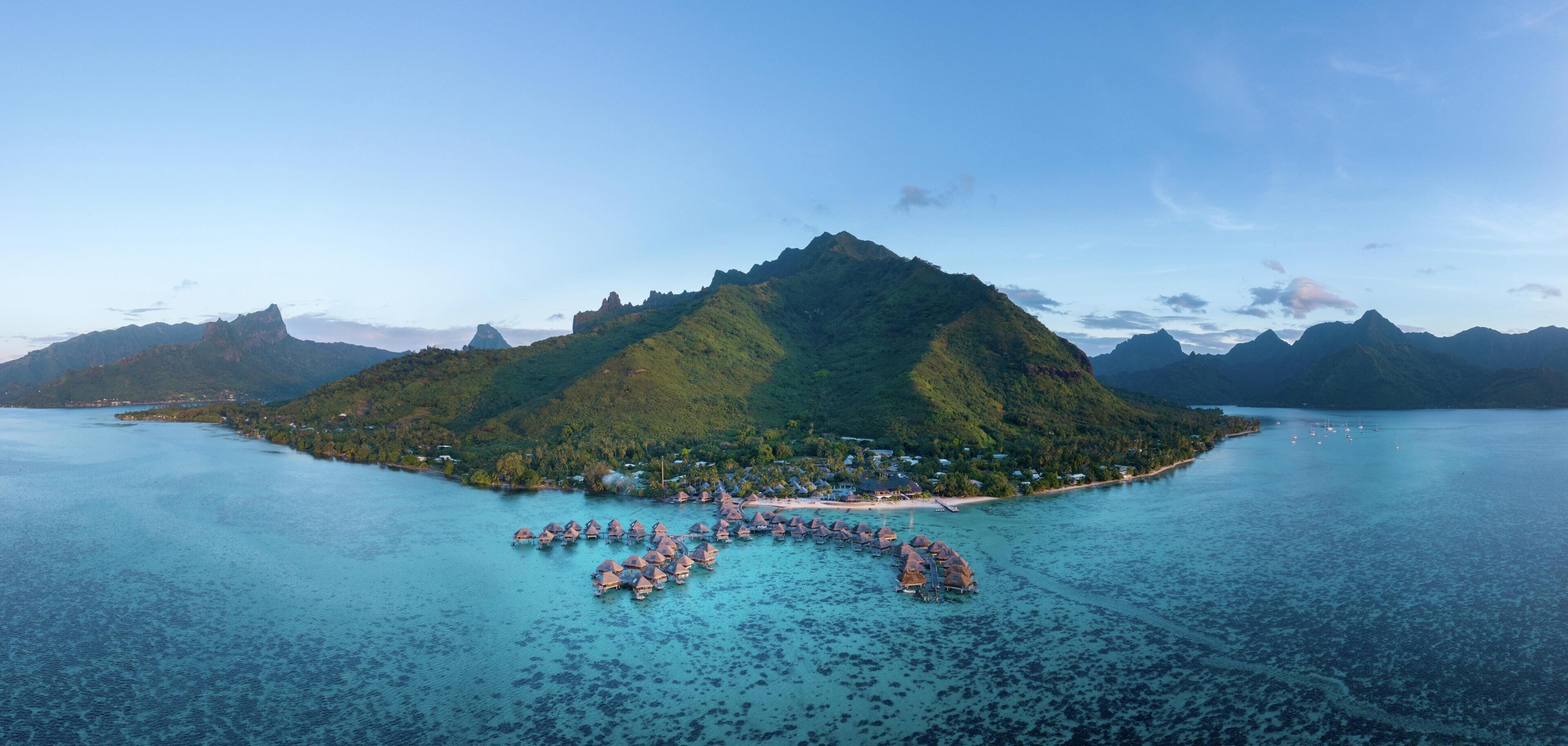 An island with a small settlement and overwater bungalows.