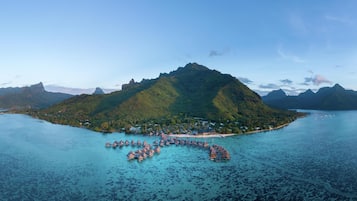 An island with a small settlement and overwater bungalows.