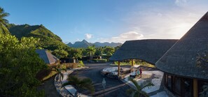 A resort with thatched-roof buildings, a paved driveway, and lush greenery. - Hilton Moorea Lagoon Resort and Spa (Moorea-Maiao)