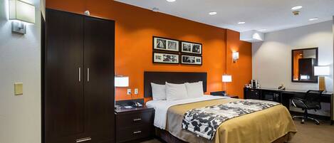 A hotel room with a large bed, a wardrobe, a desk, and a chair.