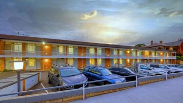 Un motel con varias habitaciones y un área de estacionamiento.