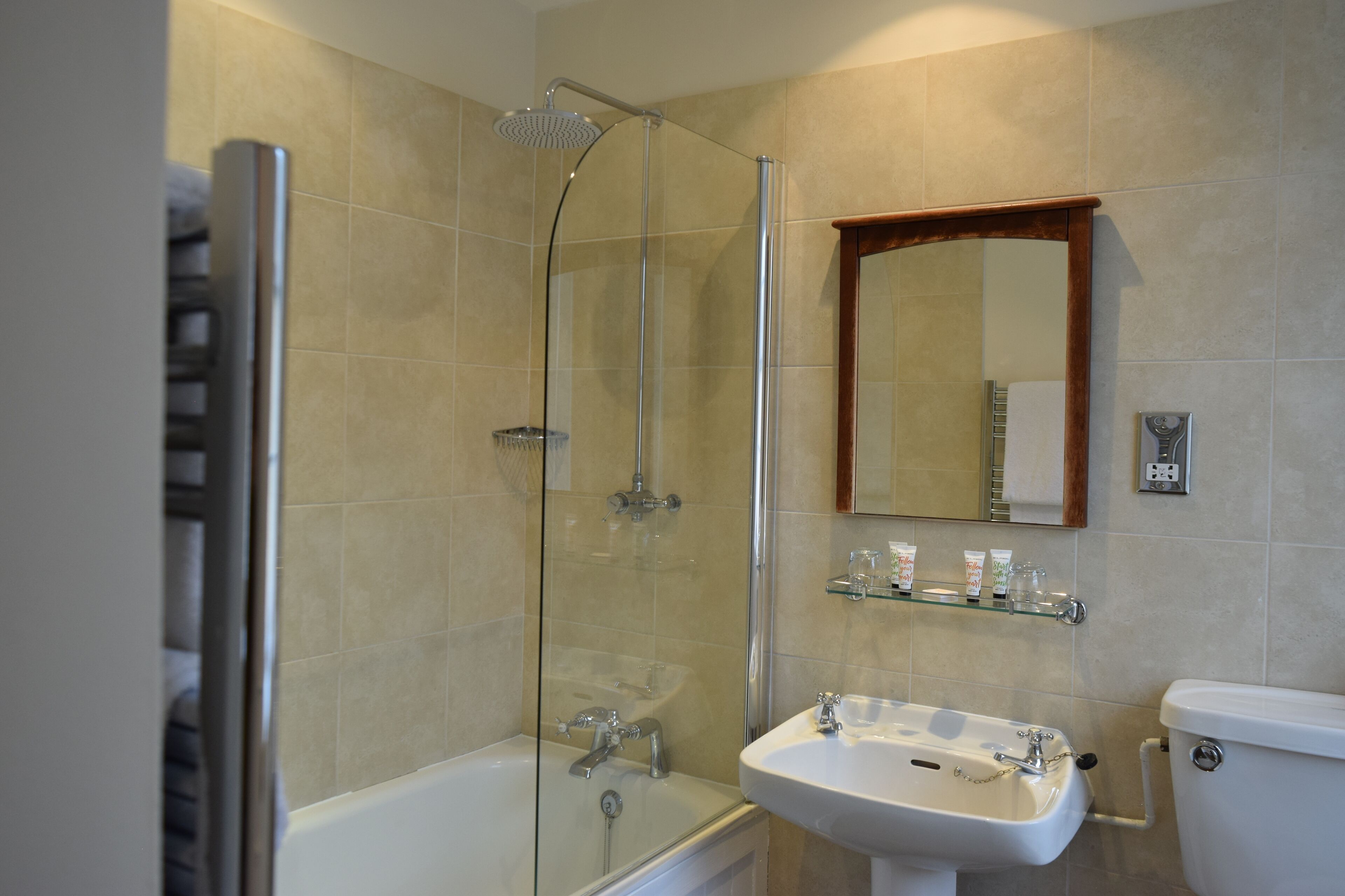 A bathroom with a glass-enclosed shower, a white sink, and a toilet.