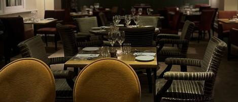 A restaurant with multiple tables set for dining, featuring chairs and dining ware.