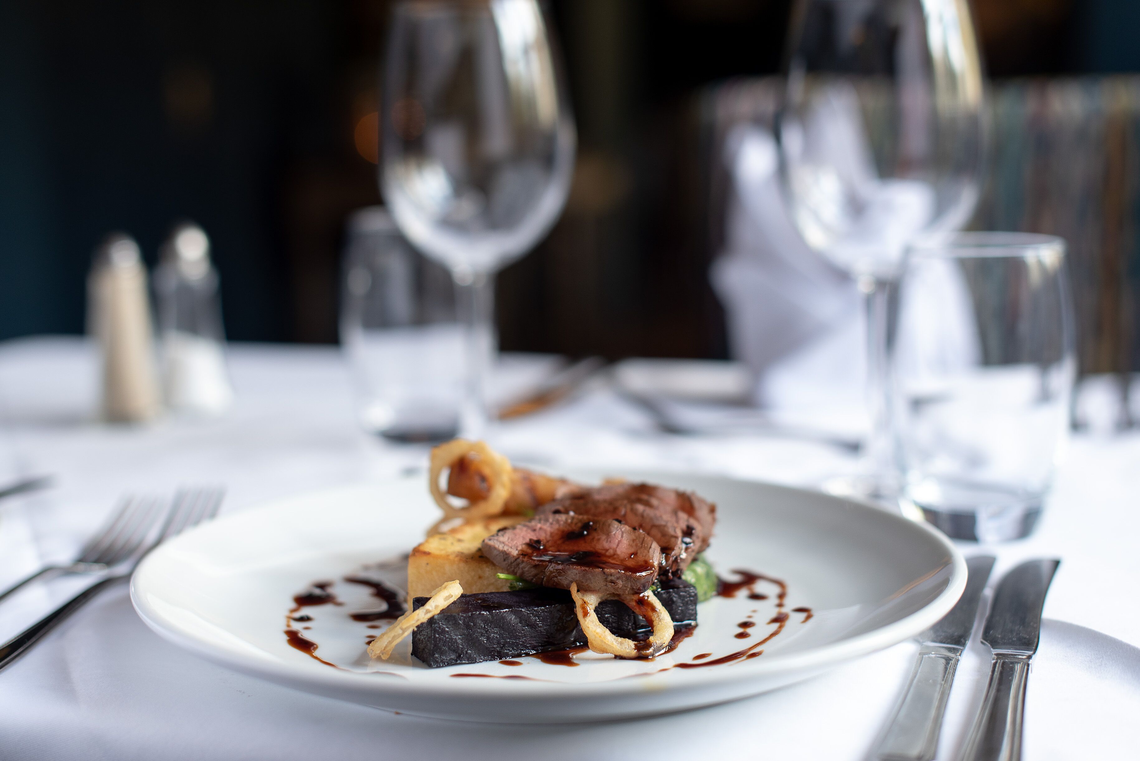 A plate of food with a fork and knife on the table.