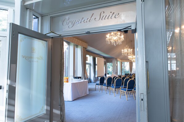 A hotel room with a large window, a chandelier, and a sign reading "Crystal Suite".