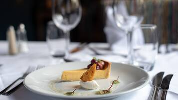 Un plato de postre con una tarta, helado y una porción de pastel sobre un mantel blanco.