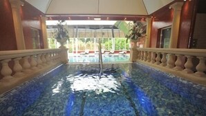 Ein Poolbereich mit klarem, blauem Wasser, einer Brüstung und Blick ins Freie.