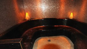 Ein Whirlpool mit Kacheln im Inneren und zwei Kerzen.