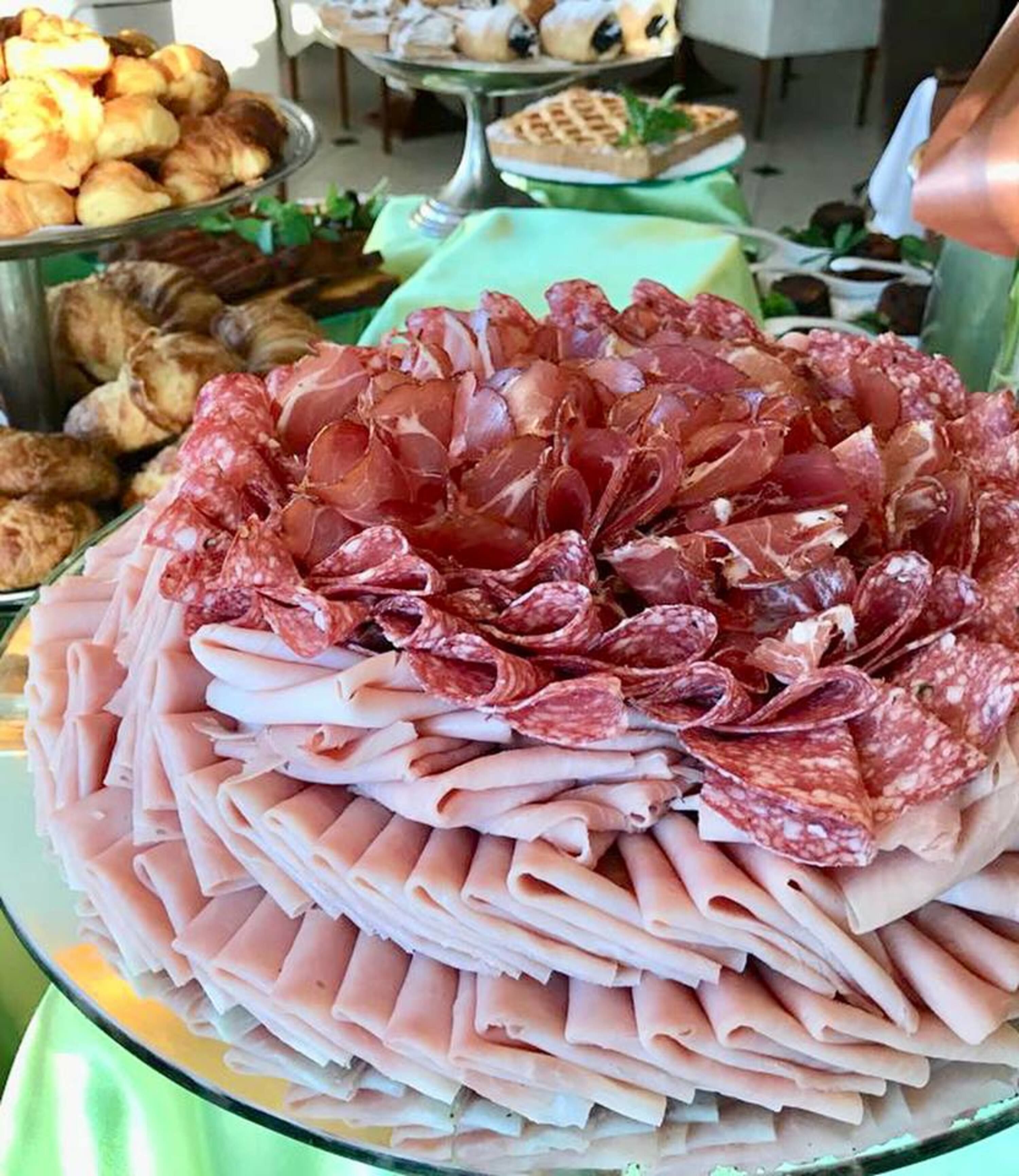 Una tabla de fiambres con diferentes carnes y pasteles.