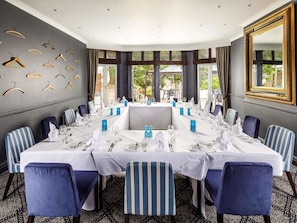 A conference room with a long table set for a meeting, surrounded by chairs with striped upholstery. - Mercure Oxford Hawkwell House Hotel (Oxford)