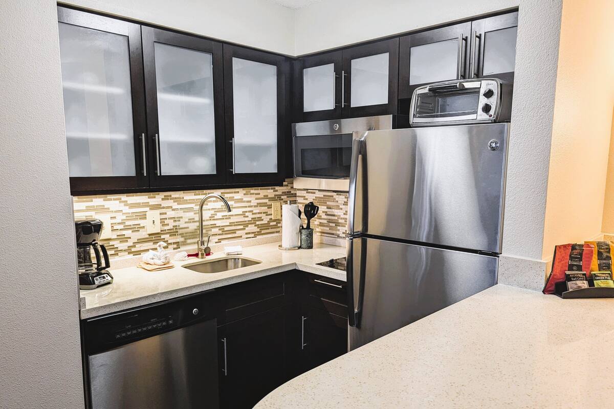 A modern kitchen with stainless steel appliances, a dishwasher, and a microwave.
