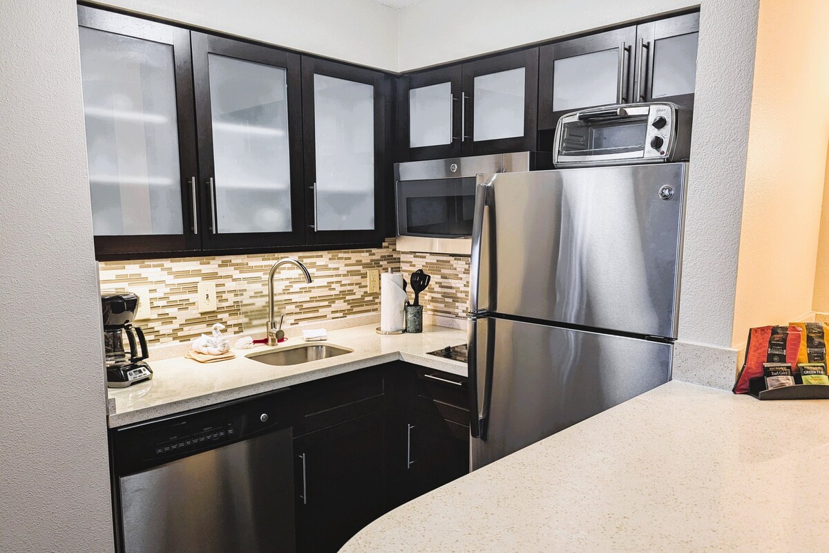 A modern kitchen with stainless steel appliances, a dishwasher, and a microwave.