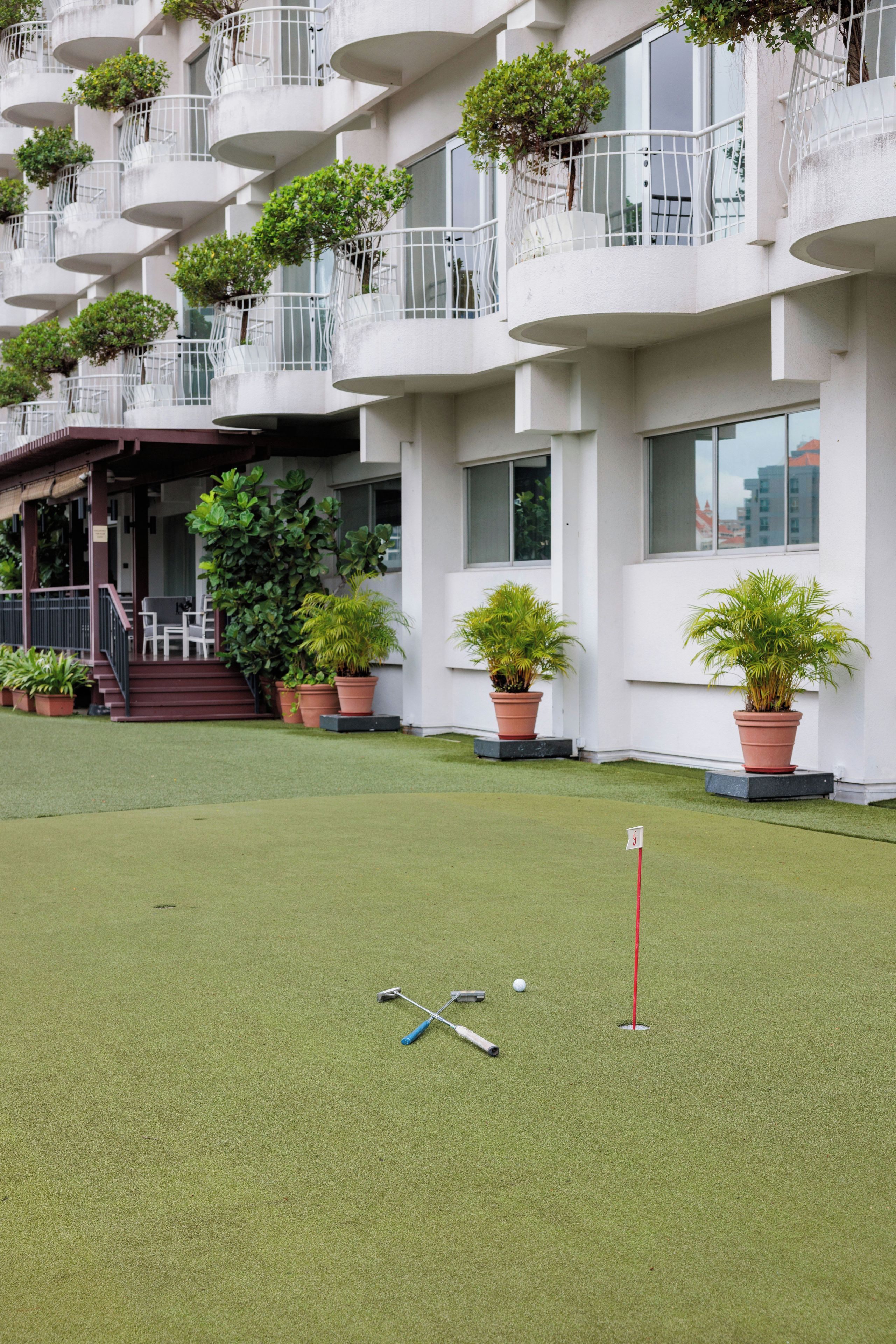 A golf course with a putting green, a golf hole, and a flagstick.