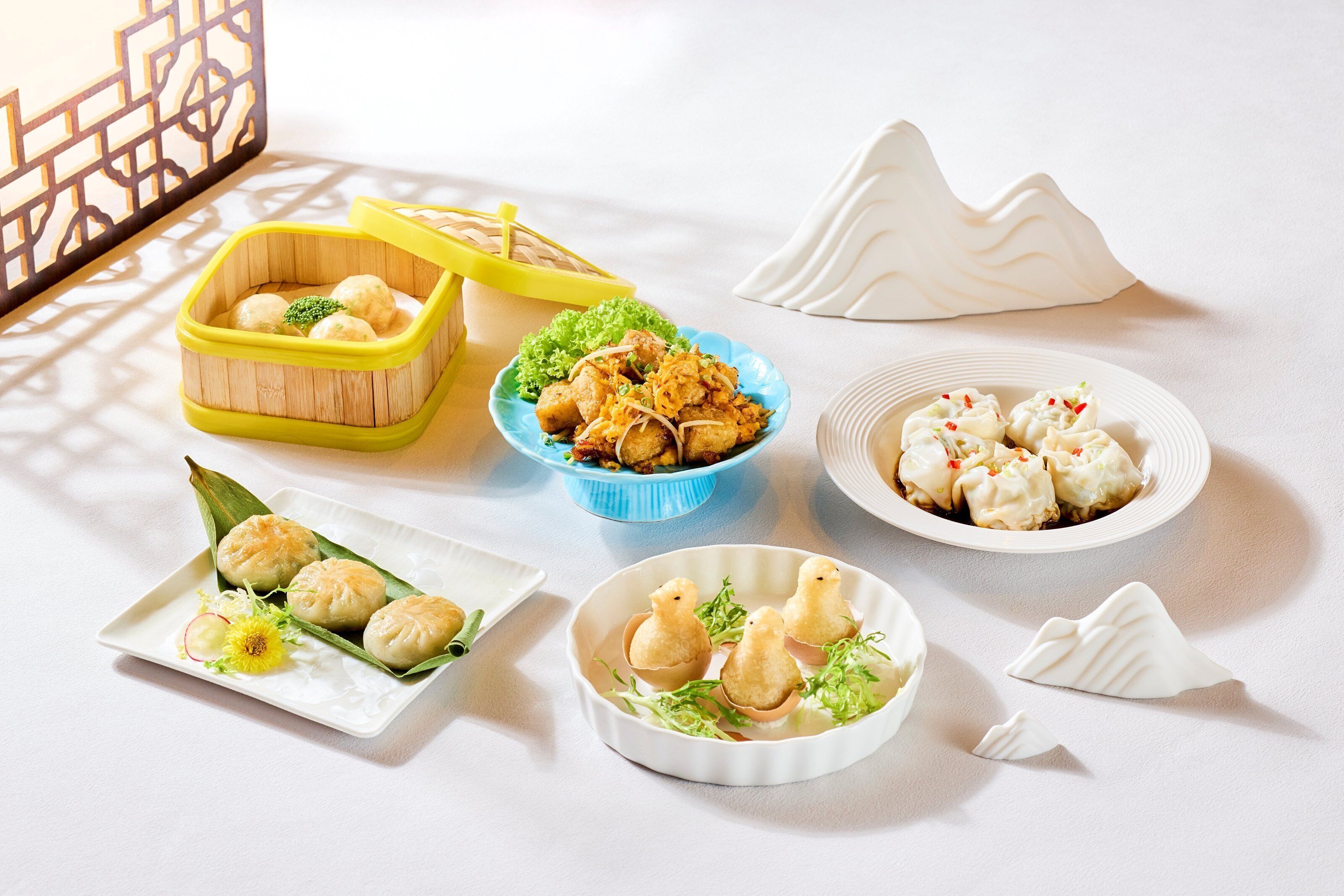 A variety of dumplings arranged on a table with different serving dishes.